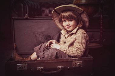 Şirin çocuk çocuk evde oynarken bir seyahat bavul. Çocukluk. Fantastik, hayal. 