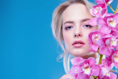 Yakın çekim portre çiçekler ile güzel bir romantik genç kadının. Kozmetik, sağlık. Güzellik, moda kavramı.