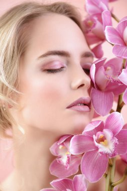 Yakın çekim portre çiçekler ile güzel bir romantik genç kadının. Kozmetik, sağlık. Güzellik, moda kavramı.