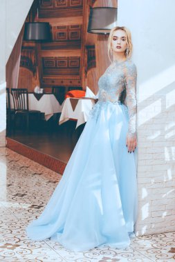 Restoranda poz güzel genç kadın akşam veya şık gelinlik giymiş. Tam uzunlukta portre. Güzellik, moda.