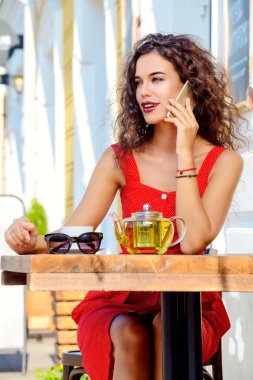 Dinlenme ve bir yaz caf çay içme sırasında sevimli esmer kadın.