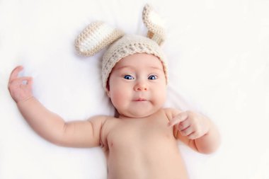 Tavşan kostüm battaniyeye yatarken şirin bebek. Aile kavramı. Paskalya tatili.
