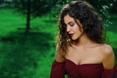Kadın büyüleyici zarif bordo elbise yaz parkta giyinmiş. Güzellik, moda kavramı.