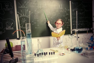 Zeki kız öğrenci tarafından bir kara tahta kimya dersi üzerinde duruyor. Eğitim kavramı.