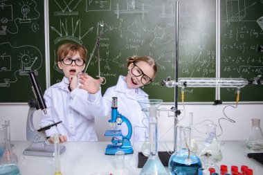 Komik kız ve erkek bilim adamları laboratuarda deney yapıyorlar. Eğitim kavramı. Erken çocuk gelişimi.