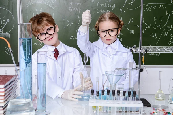 İki çocuk bilim adamları deneyler laboratuvarda yapma. Eğitim kavramı. Erken çocuk gelişimi.
