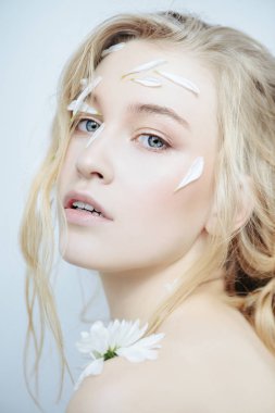 Yüz ve vücut üzerinde krizantem yaprakları olan güzel kadın. Güzellik, doğal kozmetik kavramı.