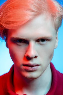 Yakın çekim portre sarışın saç stüdyoda ışık arka plan üzerinde poz ile yakışıklı bir genç adam. Erkek güzellik ve sağlık.