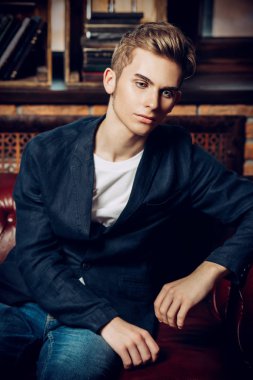 Deri kanepede poz şık giysileriyle akıllı öğrenci çocuk. Moda. Eğitim kavramı.