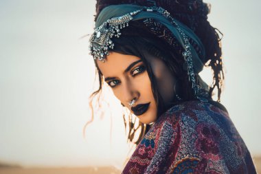 Güzel moda model güneşin ışınları boho tarzı giysilerle poz. Açık moda.