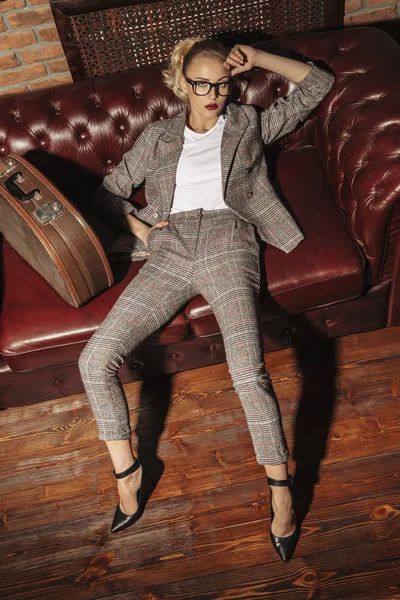 Sexy woman in a elegant suit posing in luxurious vintage interior. Full length portrait. Beauty, fashion.