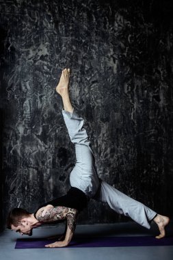 Farklı yoga gösterilen bir deneyimli yoga eğitmeni koyu arka plan üzerinde poz veriyor. Sağlıklı bir yaşam tarzı. Meditasyon, konsantrasyon.