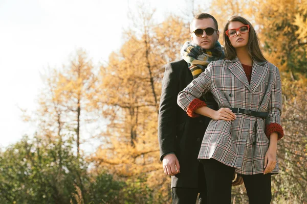 Portrait of a beautiful young people walking in the autumn park. Autumn fashion.