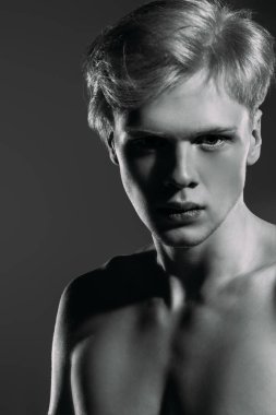Portre gömleksiz bir gencin stüdyoda poz sarışın saçlı. Gri arka plan. Erkek Sağlığı.