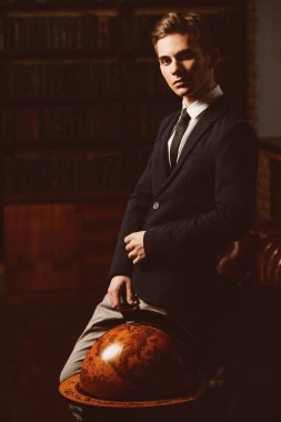 Şık giysileriyle kütüphanede duran akıllı öğrenci çocuk. Moda. Eğitim kavramı.