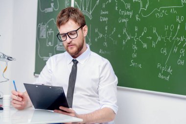 Genç akıllı öğretmen kimya dersi yürütmektedir. Eğitim kavramı.