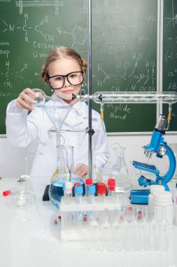 Ciddi küçük kız laboratuvarda deneyler yapıyor. Bilim ve eğitim.