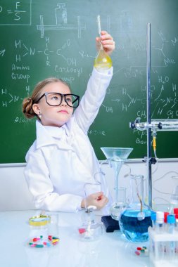 Ciddi küçük kız laboratuvarda deneyler yapıyor. Bilim ve eğitim.