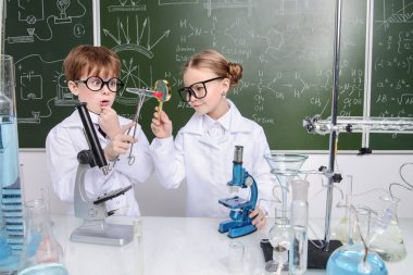 İki çocuk bilim adamları deneyler laboratuvarda yapma. Eğitim kavramı. Erken çocuk gelişimi.