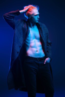 Stüdyoda gri arka plan üzerinde poz yakışıklı bir genç adam sarı saçlı bir ekose ceket giyen portresi. Erkek güzellik ve sağlık.