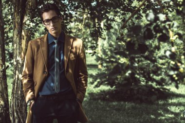 İş kıyafetleri bir yaz parkta poz zarif bir genç adam portresi. Açık moda. İş tarzı. 