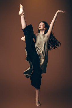 Uzun kıvırcık kırmızı saçlı modern on beş yaşındaki kız stüdyoda dans ediyor. Güzellik, moda. Vogue dans.