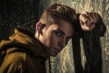 Grunge arka plan üzerinde üzgün bir genç çocuk portresi. Stüdyo vurdu. Genç moda.