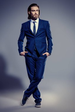 Moda vurdu. Zarif mavi elbise ve beyaz gömlek poz yakışıklı delikanlı. Erkek güzelliği, moda.