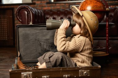 Şirin çocuk çocuk evde oynarken bir seyahat bavul. Çocukluk. Fantastik, hayal. 