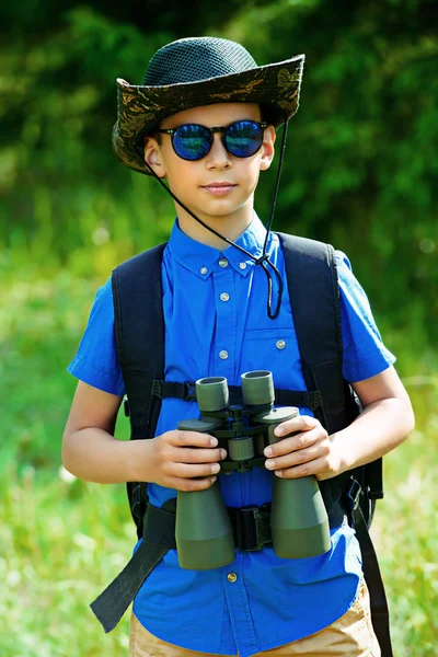 On yıl yaşlı erkek çocuk gitmek hiking sırt çantası ve dürbün ile. Dünya keşfetmek. Yaz tatili. Açık hava etkinlikleri.