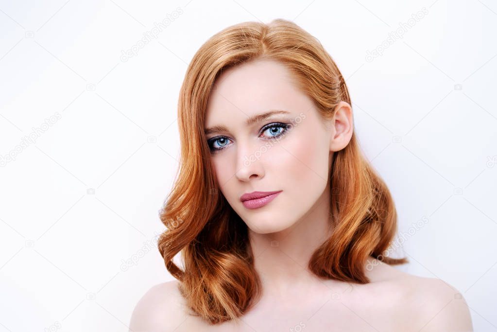 Close-up portrait of a beautiful young woman with natural makeup. White background. Beauty, cosmetics, makeup. Hair styling.