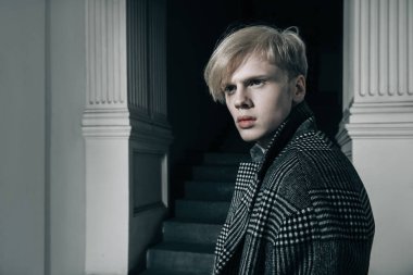 Sarı saçlı bir şehir sokakta duran bir ekose ceket giyiyor ile yakışıklı bir genç adam portresi. Erkek güzellik ve sağlık. Güzellik, şehir moda.