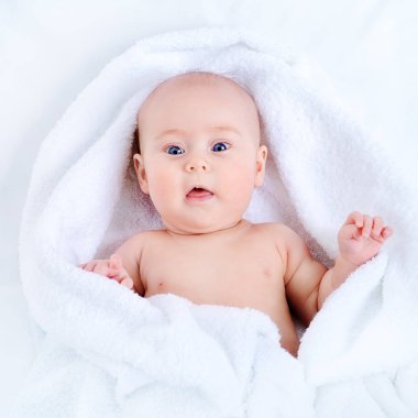 Tatlı bebek banyo sonra beyaz bir havlu. Sağlık, pediatri.