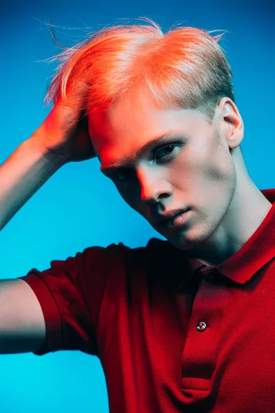 Yakın çekim portre sarışın saç stüdyoda ışık arka plan üzerinde poz ile yakışıklı bir genç adam. Erkek güzellik ve sağlık.