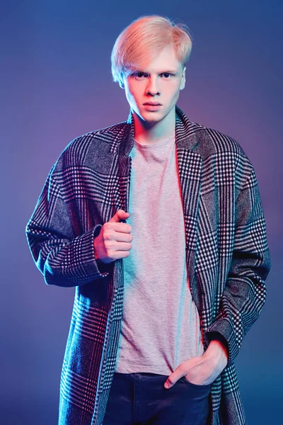 Stüdyoda gri arka plan üzerinde poz yakışıklı bir genç adam sarı saçlı bir ekose ceket giyen portresi. Erkek güzellik ve sağlık.