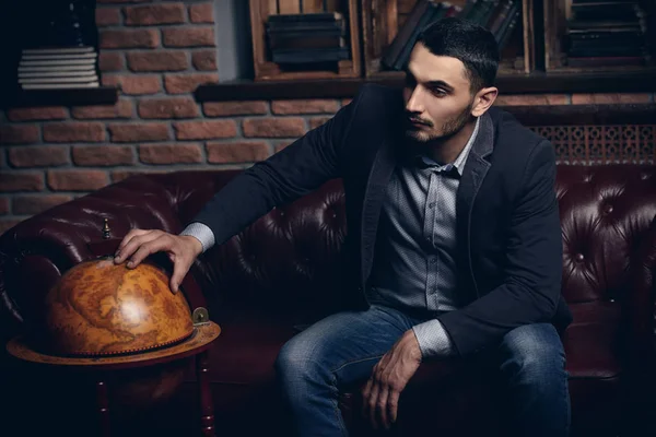 Deri koltuk üzerinde seksi yakışıklı bir adam portresi. Moda vurdu. Erkek güzelliği, moda. Erkek Berber Dükkanı, saç modeli.