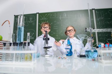 Komik kız ve erkek bilim adamları laboratuarda deney yapıyorlar. Eğitim kavramı. Erken çocuk gelişimi.