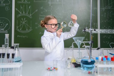 Ciddi küçük kız laboratuvarda deneyler yapıyor. Bilim ve eğitim.