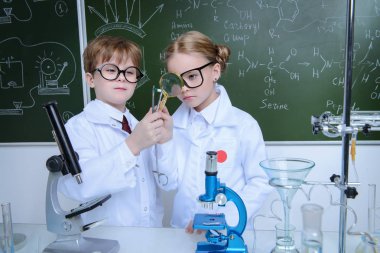 İki çocuk bilim adamları deneyler laboratuvarda yapma. Eğitim kavramı. Erken çocuk gelişimi.