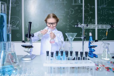Ciddi küçük kız laboratuvarda deneyler yapıyor. Bilim ve eğitim.