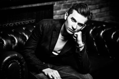 Deri kanepede poz şık giysileriyle akıllı öğrenci çocuk. Moda. Eğitim kavramı.