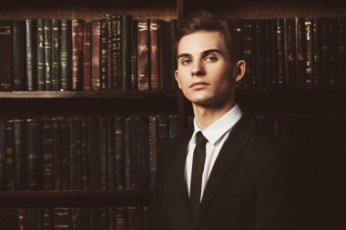 Şık giysileriyle kütüphanede duran akıllı öğrenci çocuk. Moda. Eğitim kavramı.