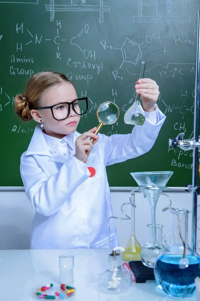 Ciddi küçük kız laboratuvarda deneyler yapıyor. Bilim ve eğitim.