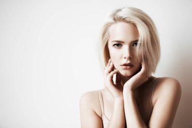 Koyu arka plan üzerinde çıplak makyaj güzel bir sarışın kadınla yakın çekim portre. Güzellik, moda kavramı. Kalıcı makyaj ve kozmetik. Kısa saçlar için saç kesimi.