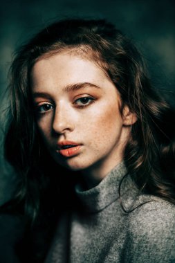 Yakın çekim grunge arka plan üzerinde uzun kıvırcık kırmızı saçlı bir on beş yaşındaki kız portresi. Güzellik, moda.