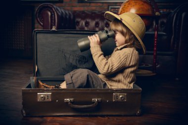 Şirin çocuk çocuk evde oynarken bir seyahat bavul. Çocukluk. Fantastik, hayal. 