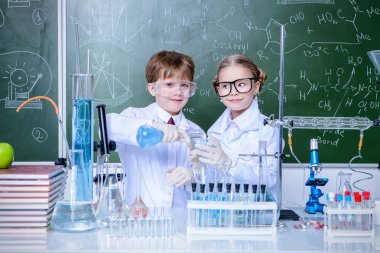 İki çocuk bilim adamları deneyler laboratuvarda yapma. Eğitim kavramı. Erken çocuk gelişimi.