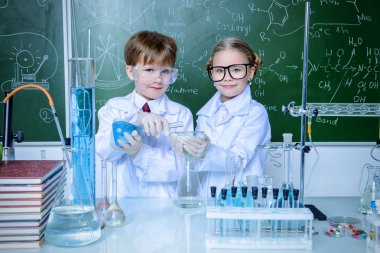 İki çocuk bilim adamları deneyler laboratuvarda yapma. Eğitim kavramı. Erken çocuk gelişimi.