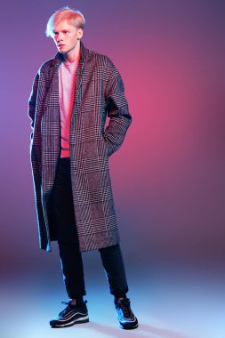 Vogue yakışıklı bir erkek model gri arka plan üzerinde kareli ceket daimi bir kadeh. Tam uzunlukta portre. Erkek güzelliği, moda. 