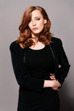 Siyah uygun elbise ve ceket giyen zarif genç kadın. Güzellik, moda kavramı. Stüdyo vurdu.